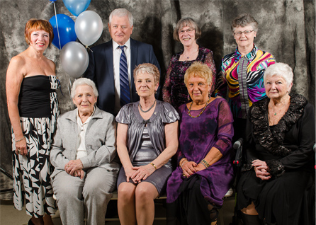 Group of men and women in formal poise.